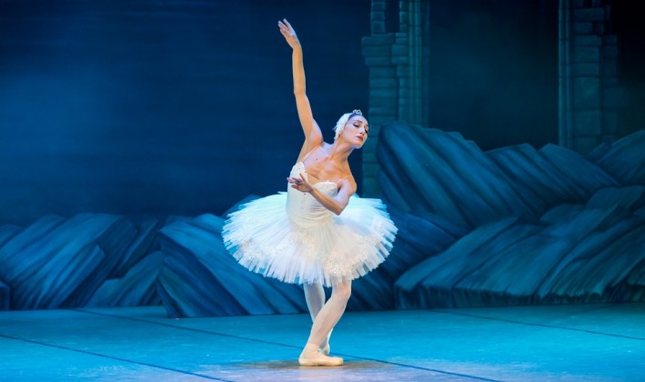 ballerina in white swan costume performing on stage
